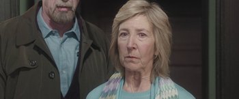 Movie still from “Insidious: Chapter 2” (2013), directed by James Wan – An older woman wearing a blue sweater and a man wearing a green jacket; Close Up shot, Over the shoulder angle