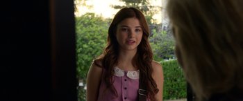 Movie still from “Insidious: Chapter 3” (2015), directed by Leigh Whannell – A young woman with long brown hair wearing a pink dress; Close Up shot, Over the shoulder angle