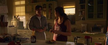 Movie still from “Insidious: Chapter 3” (2015), directed by Leigh Whannell – A man and a woman standing next to each other in a kitchen; Medium shot, Over the shoulder angle