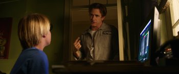 Movie still from “Insidious: Chapter 3” (2015), directed by Leigh Whannell – A man standing in front of a mirror in a room; Medium shot, Over the shoulder angle