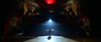 Movie still from “Insidious: Chapter 3” (2015), directed by Leigh Whannell – A person standing in a theater with a light shining on them; Extreme Wide shot, Low angle