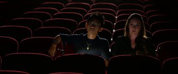 Movie still from “Insidious: Chapter 3” (2015), directed by Leigh Whannell – A man sitting in a movie theater with his eyes closed; Medium shot, High angle