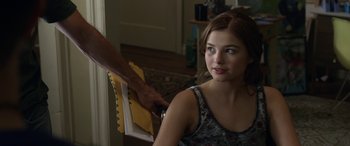 Movie still from “Insidious: Chapter 3” (2015), directed by Leigh Whannell – A woman sitting in front of a person cutting paper with a pair of shears; Close Up shot, Over the shoulder angle