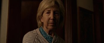 Movie still from “Insidious: Chapter 3” (2015), directed by Leigh Whannell – An older woman wearing a sweater and a necklace; Close Up shot, Over the shoulder angle