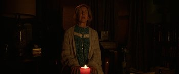 Movie still from “Insidious: Chapter 3” (2015), directed by Leigh Whannell – An older woman sitting in a chair with a lit candle; Medium shot, Low angle