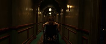 Movie still from “Insidious: Chapter 3” (2015), directed by Leigh Whannell – A person in a wheelchair in a hallway; Wide shot, High angle