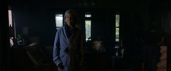 Movie still from “Insidious: Chapter 3” (2015), directed by Leigh Whannell – An older woman standing in a dark room; Medium shot, Low angle