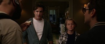 Movie still from “Insidious: Chapter 3” (2015), directed by Leigh Whannell – A man standing next to a young boy in a kitchen; Medium shot, Over the shoulder angle