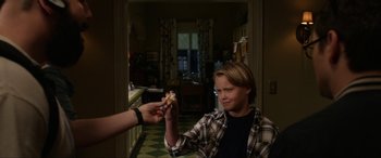 Movie still from “Insidious: Chapter 3” (2015), directed by Leigh Whannell – A boy holding a hot dog in his hand; Medium shot, Over the shoulder angle