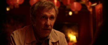 Movie still from “Insidious: Chapter 3” (2015), directed by Leigh Whannell – An older man with a goatee stares into the camera; Close Up shot, Over the shoulder angle