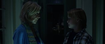 Movie still from “Insidious: Chapter 3” (2015), directed by Leigh Whannell – A woman and a boy talking in a dark room; Medium shot, Over the shoulder angle
