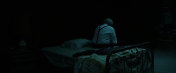 Movie still from “Insidious: Chapter 3” (2015), directed by Leigh Whannell – An old man sitting on a bed in the dark; Wide shot, High angle