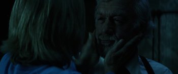 Movie still from “Insidious: Chapter 3” (2015), directed by Leigh Whannell – An older man and a young woman in the dark; Close Up shot, Over the shoulder angle