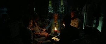 Movie still from “Insidious: Chapter 3” (2015), directed by Leigh Whannell – A group of people gathered around a candle; Medium shot, High angle