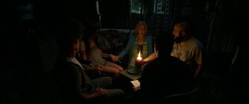 Movie still from “Insidious: Chapter 3” (2015), directed by Leigh Whannell – A group of people gathered around a candle; Medium shot, High angle