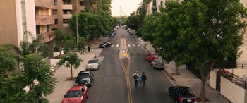Movie still from “Insidious: Chapter 3” (2015), directed by Leigh Whannell – Three people walking down a street near some parked cars; Extreme Wide shot, High angle