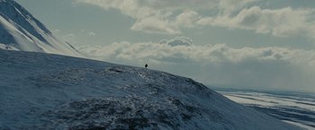 Movie still from “Into the Wild” (2007), directed by Sean Penn – A person standing on top of a snow covered hill; Extreme Wide shot, Low angle