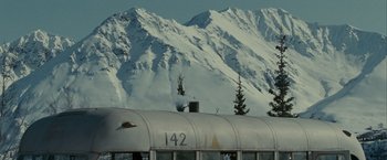 Movie still from “Into the Wild” (2007), directed by Sean Penn – A train traveling past a snowy mountainous area; Extreme Wide shot, Low angle