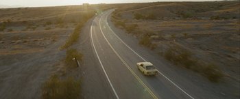 Movie still from “Into the Wild” (2007), directed by Sean Penn – A car driving down the middle of a road; Extreme Wide shot, High angle