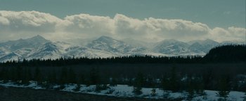 Movie still from “Into the Wild” (2007), directed by Sean Penn – A view of a mountain range with snow on the ground; Extreme Wide shot, High angle