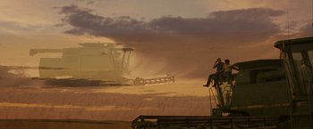 Movie still from “Into the Wild” (2007), directed by Sean Penn – A person sitting on top of a truck in the middle of a field; Extreme Wide shot, Low angle