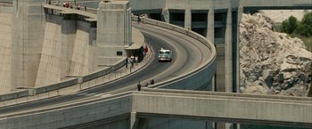 Movie still from “Into the Wild” (2007), directed by Sean Penn – A bus driving down a curvy road in a parking lot; Extreme Wide shot, High angle