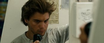 Movie still from “Into the Wild” (2007), directed by Sean Penn – A young man is holding a hair dryer; Close Up shot, Over the shoulder angle