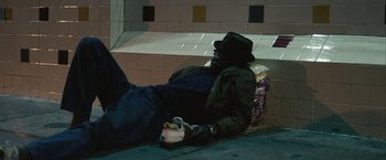 Movie still from “Into the Wild” (2007), directed by Sean Penn – A man laying on the ground with his feet on the ground; Wide shot, High angle
