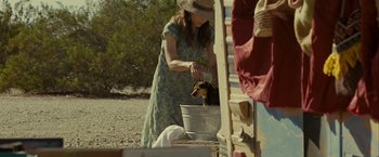 Movie still from “Into the Wild” (2007), directed by Sean Penn – A woman washing a dog in a bucket; Medium shot, Over the shoulder angle