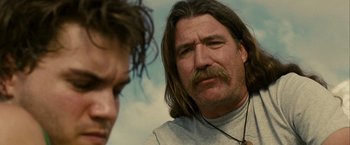 Movie still from “Into the Wild” (2007), directed by Sean Penn – A person with long hair and a mustache; Close Up shot, Over the shoulder angle