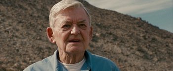 Movie still from “Into the Wild” (2007), directed by Sean Penn – An old man with a white beard and a blue shirt; Close Up shot, Low angle