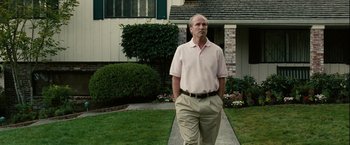Movie still from “Into the Wild” (2007), directed by Sean Penn – A man standing in front of a house on a sidewalk; Medium shot, Low angle