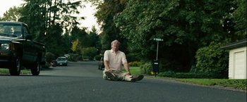 Movie still from “Into the Wild” (2007), directed by Sean Penn – A man sitting on the side of a road; Wide shot, Low angle