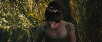 Movie still from “Into the Woods” (2014), directed by Rob Marshall – A woman wearing a tiara and a green dress; Medium shot, Overhead angle