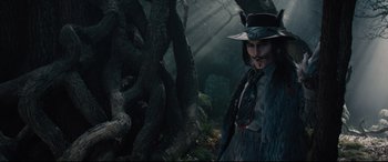 Movie still from “Into the Woods” (2014), directed by Rob Marshall – A man in a hat and a long coat standing in the woods; Medium shot, Low angle