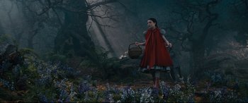 Movie still from “Into the Woods” (2014), directed by Rob Marshall – A little red riding hood walking through the woods; Wide shot, High angle