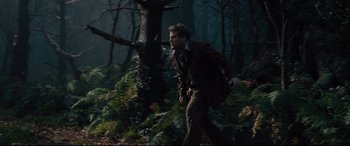 Movie still from “Into the Woods” (2014), directed by Rob Marshall – A man running through the woods with a backpack; Wide shot, Low angle