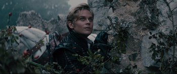 Movie still from “Into the Woods” (2014), directed by Rob Marshall – A man in a leather jacket standing next to a rock wall; Close Up shot, Low angle