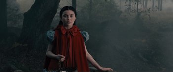Movie still from “Into the Woods” (2014), directed by Rob Marshall – A woman in a red cape standing in the woods; Medium shot, Low angle