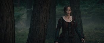 Movie still from “Into the Woods” (2014), directed by Rob Marshall – A woman standing in front of a tree in the woods; Medium shot, Over the shoulder angle