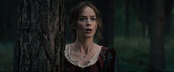 Movie still from “Into the Woods” (2014), directed by Rob Marshall – A woman standing next to a tree looking at the camera; Close Up shot, Low angle