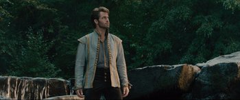 Movie still from “Into the Woods” (2014), directed by Rob Marshall – A man wearing a blue and gold jacket standing in front of trees; Medium shot, Low angle