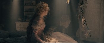 Movie still from “Into the Woods” (2014), directed by Rob Marshall – A woman with long blonde hair sitting on top of a bed; Medium shot, Over the shoulder angle