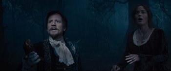 Movie still from “Into the Woods” (2014), directed by Rob Marshall – A man standing in the dark in front of a forest; Medium shot, Over the shoulder angle