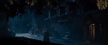 Movie still from “Into the Woods” (2014), directed by Rob Marshall – A person walking in front of a building at night; Extreme Wide shot, High angle