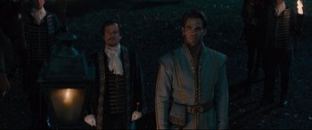 Movie still from “Into the Woods” (2014), directed by Rob Marshall – Two men dressed in medieval clothing standing next to each other; Medium shot, Over the shoulder angle