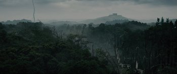 Movie still from “Into the Woods” (2014), directed by Rob Marshall – A view of trees and a castle in the distance; Extreme Wide shot, High angle