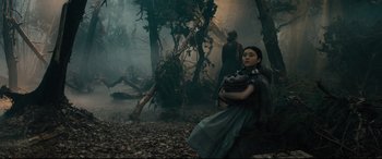 Movie still from “Into the Woods” (2014), directed by Rob Marshall – A woman holding a baby in a forest; Wide shot, Low angle