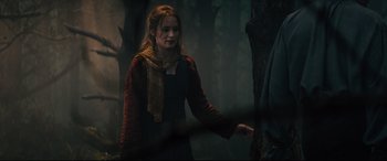 Movie still from “Into the Woods” (2014), directed by Rob Marshall – A woman is standing in the woods near a tree; Medium shot, Over the shoulder angle