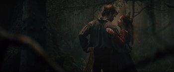 Movie still from “Into the Woods” (2014), directed by Rob Marshall – A man and a woman standing next to each other in a forest; Medium shot, Low angle